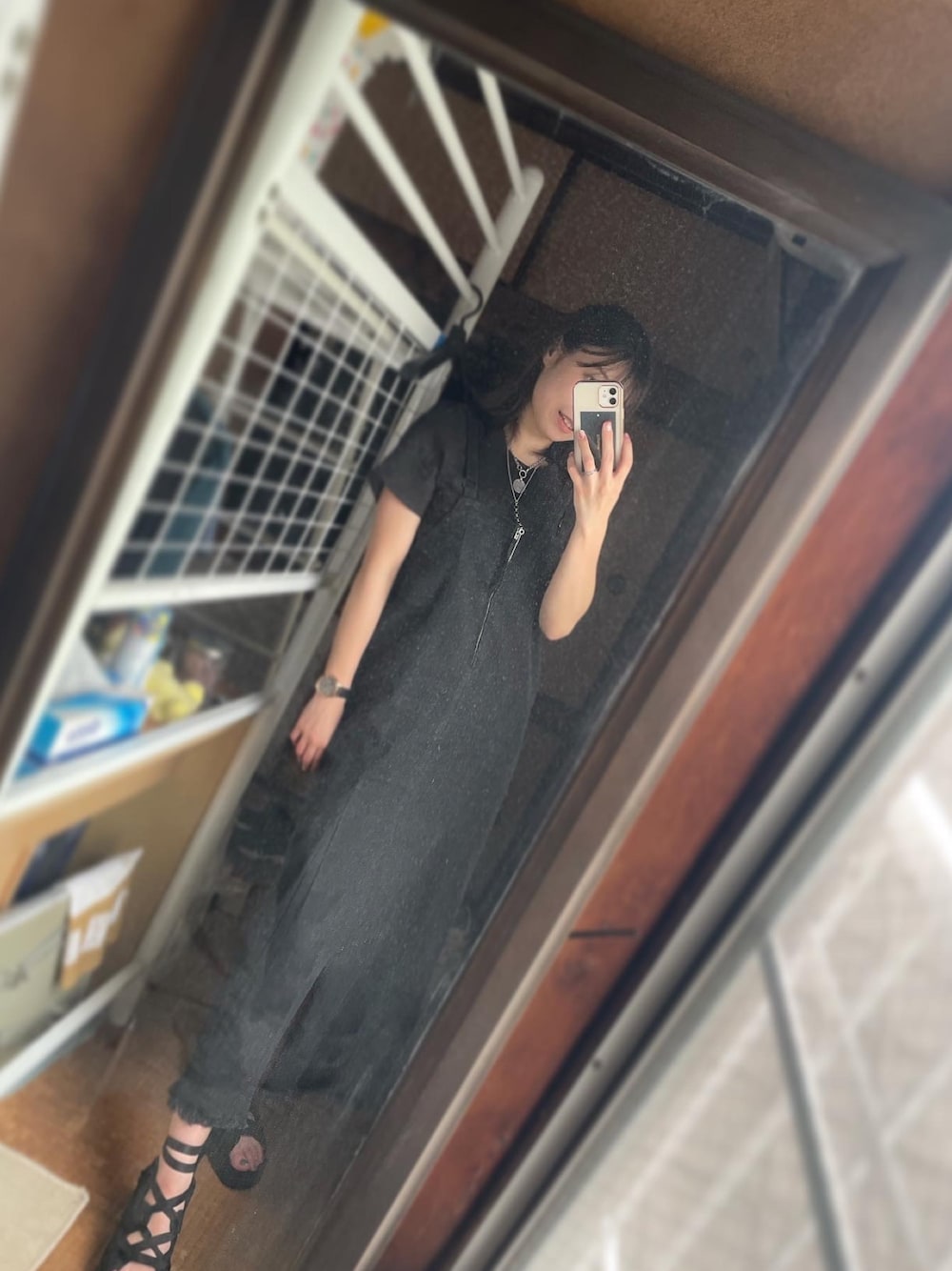 ブラック系のジャンパースカート、ブラック系のTシャツ/カットソー、ブラック系のサンダルを着用したレディースの春コーディネートの1枚目の写真