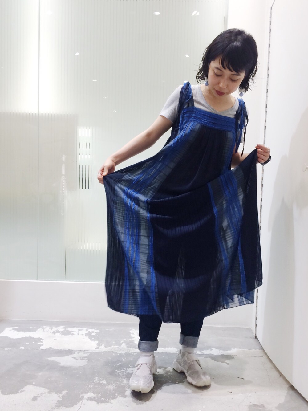 ブルー系のワンピース、ブルー系のデニムパンツ、ホワイト系のスニーカーを着用したレディースの夏コーディネートの1枚目の写真