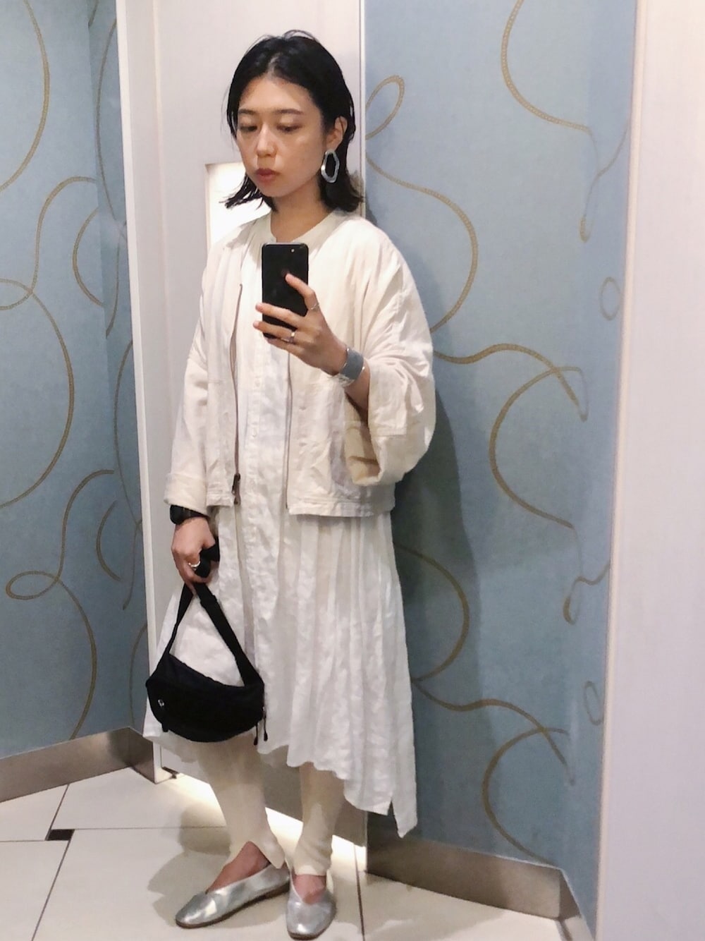 ホワイト系のワンピース、ブラック系のボディバッグ/ウエストポーチ、ホワイト系のブルゾンを着用したレディースの秋コーディネートの1枚目の写真