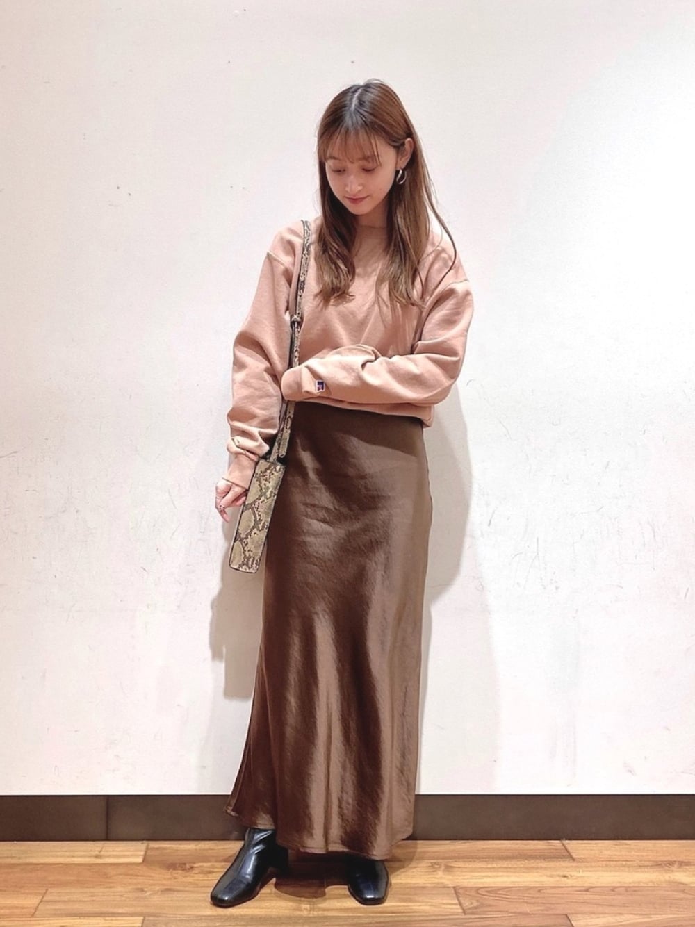 ブラウン系のその他トップス、ブラウン系のスカート、ベージュ系のショルダーバッグを着用したレディースの冬コーディネートの1枚目の写真