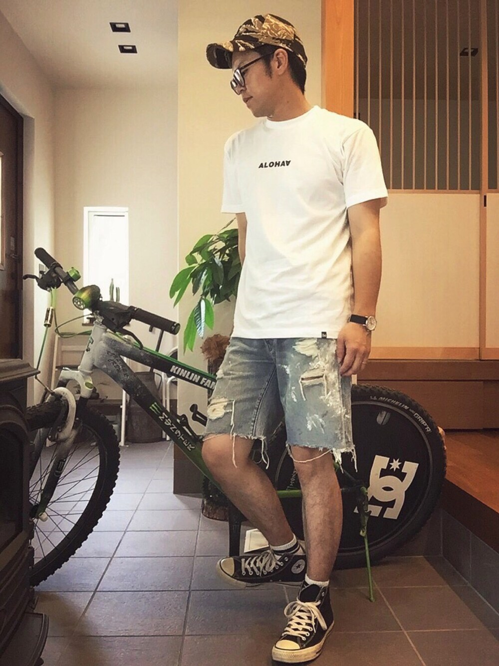 ブルー系のデニムパンツ、ホワイト系のTシャツ/カットソー、ブラック系のスニーカーを着用したメンズの夏コーディネートの1枚目の写真