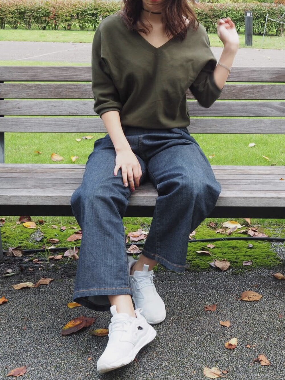 グリーン系のTシャツ/カットソー、ブルー系のデニムパンツ、ホワイト系のスニーカーを着用したレディースの冬コーディネートの1枚目の写真