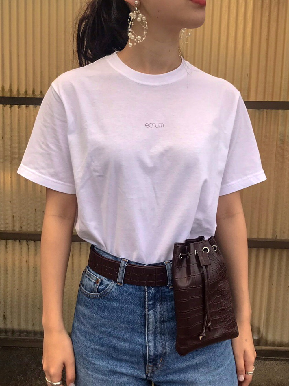 ホワイト系のTシャツ/カットソー、ブラック系のバッグ、ホワイト系のピアス（両耳用）を着用したレディースの夏コーディネートの1枚目の写真