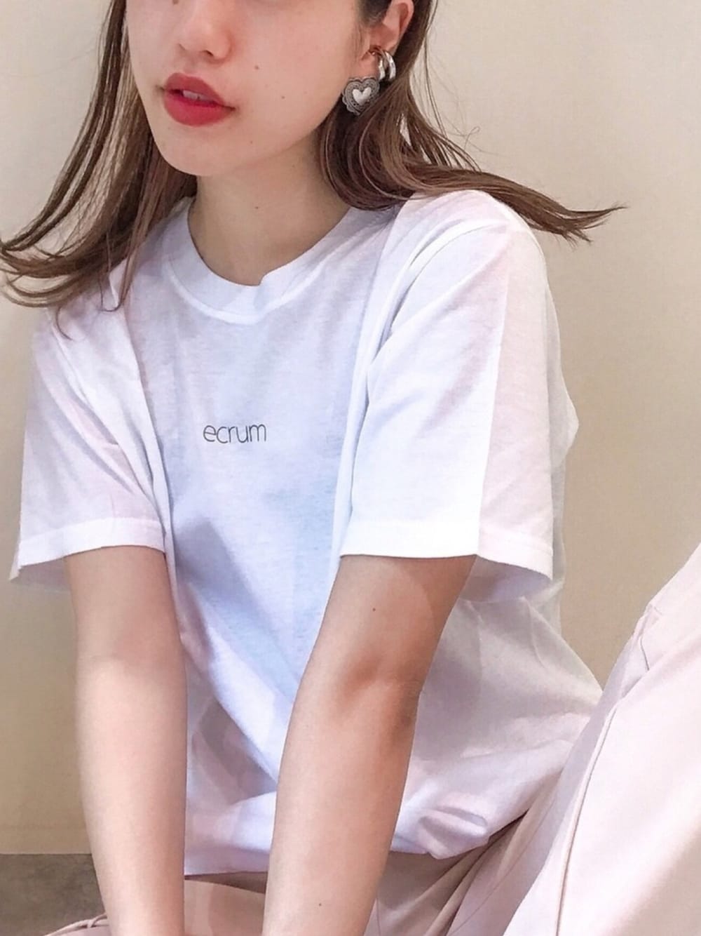 ホワイト系のTシャツ/カットソー、ベージュ系のパンツ、シルバー系のイヤリング（片耳用）を着用したレディースの夏コーディネートの1枚目の写真