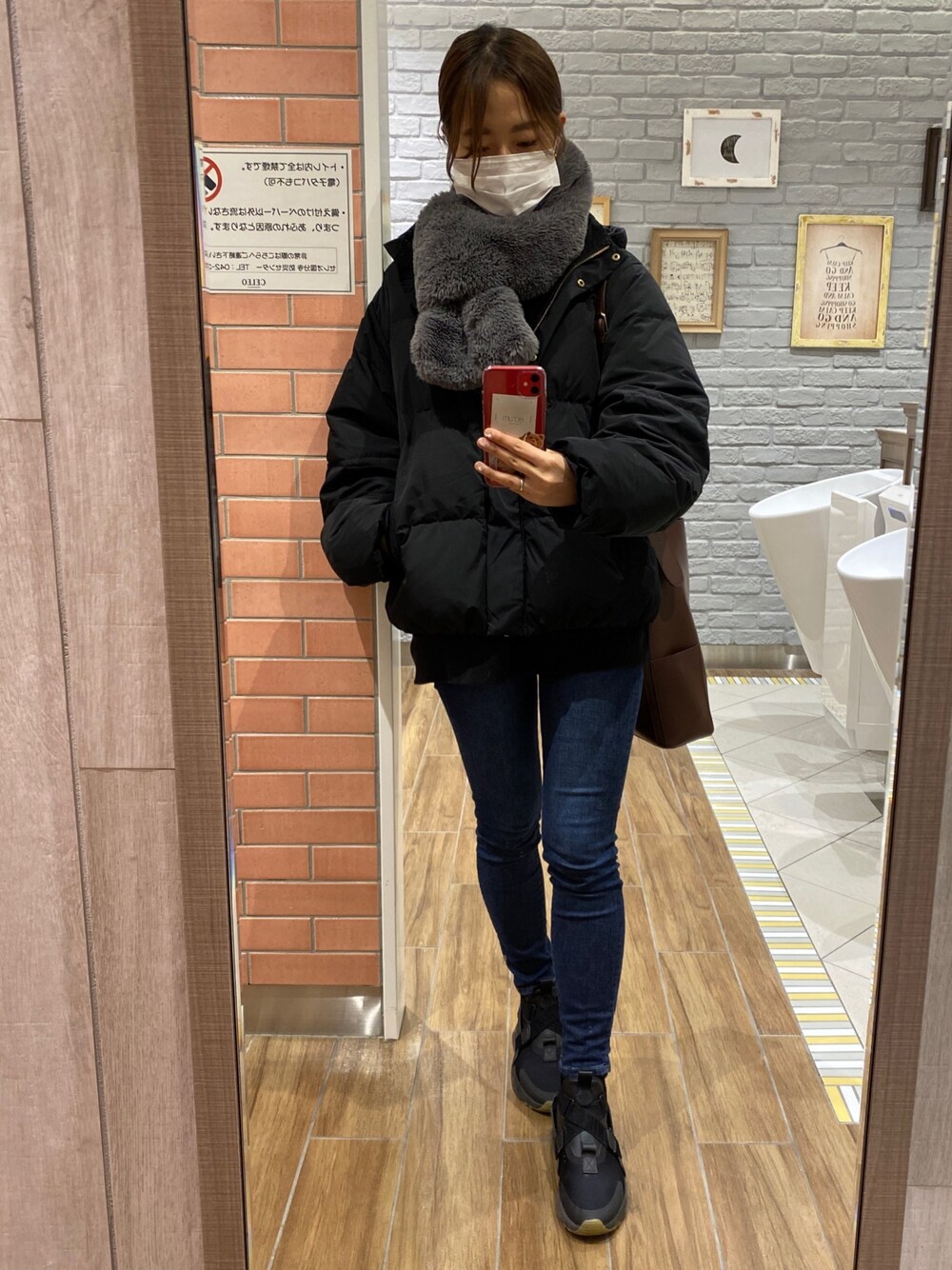 ブルー系のデニムパンツ、ブラック系のスニーカーを着用したレディースの冬コーディネートの1枚目の写真