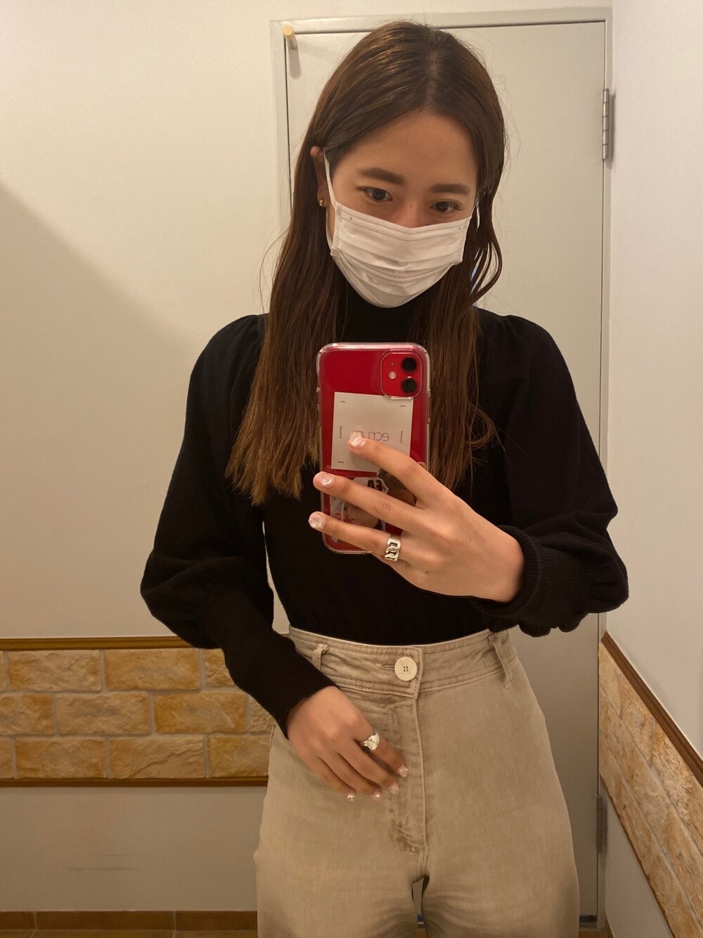 ブラック系のニット/セーター、ベージュ系のデニムパンツ、シルバー系のリングを着用したレディースの冬コーディネートの1枚目の写真