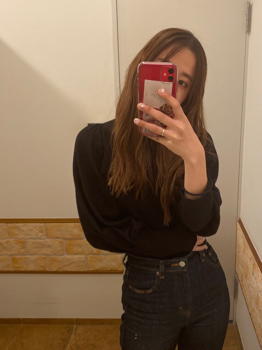 ブラック系のニット/セーター、ブルー系のデニムパンツを着用したレディースの冬コーディネートの1枚目の写真