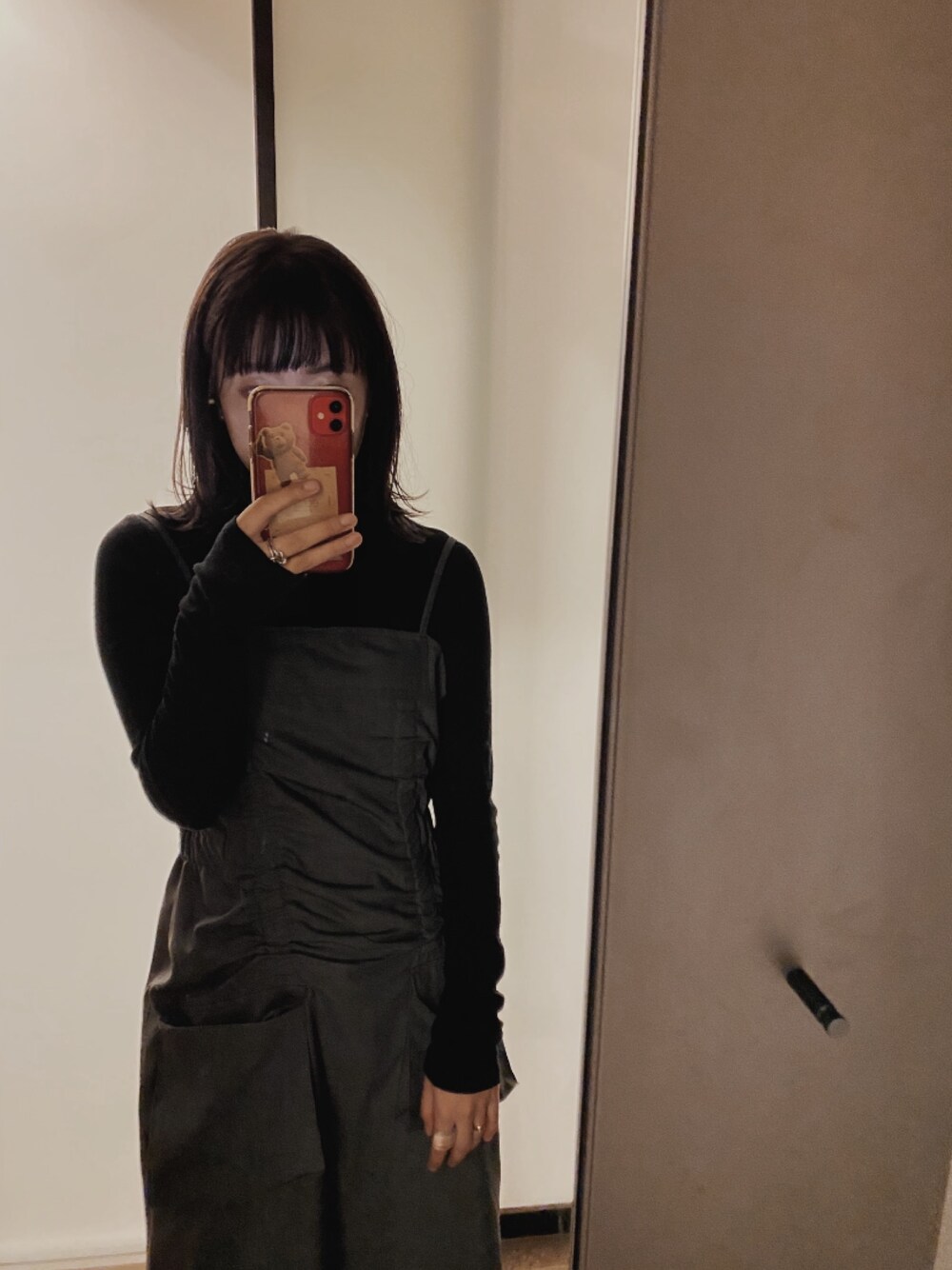 グレー系のワンピース、ブラック系のニット/セーター、ホワイト系のリングを着用したレディースの冬コーディネートの1枚目の写真