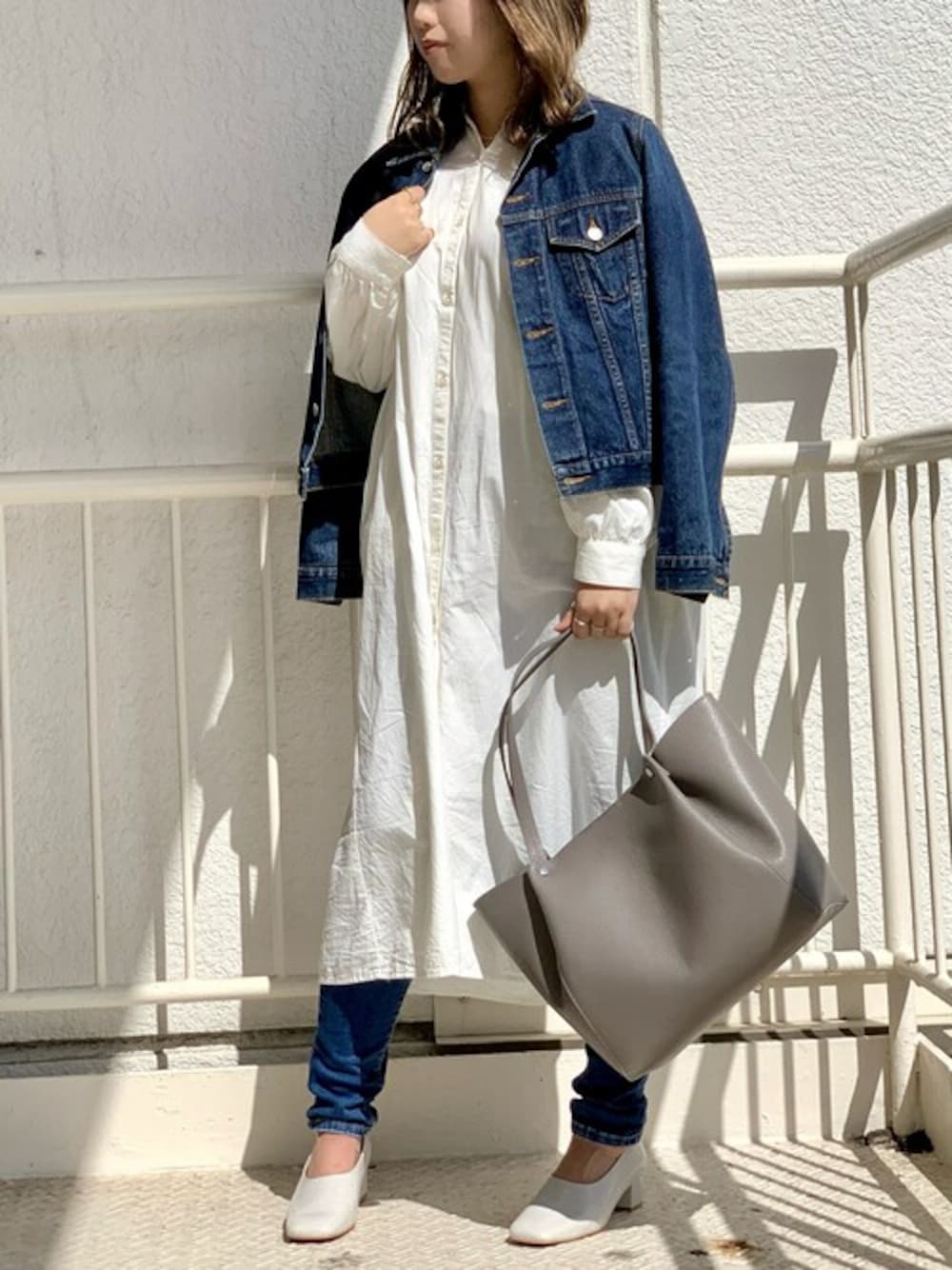 グレー系のトートバッグ、ベージュ系のパンプスを着用したレディースの春コーディネートの1枚目の写真