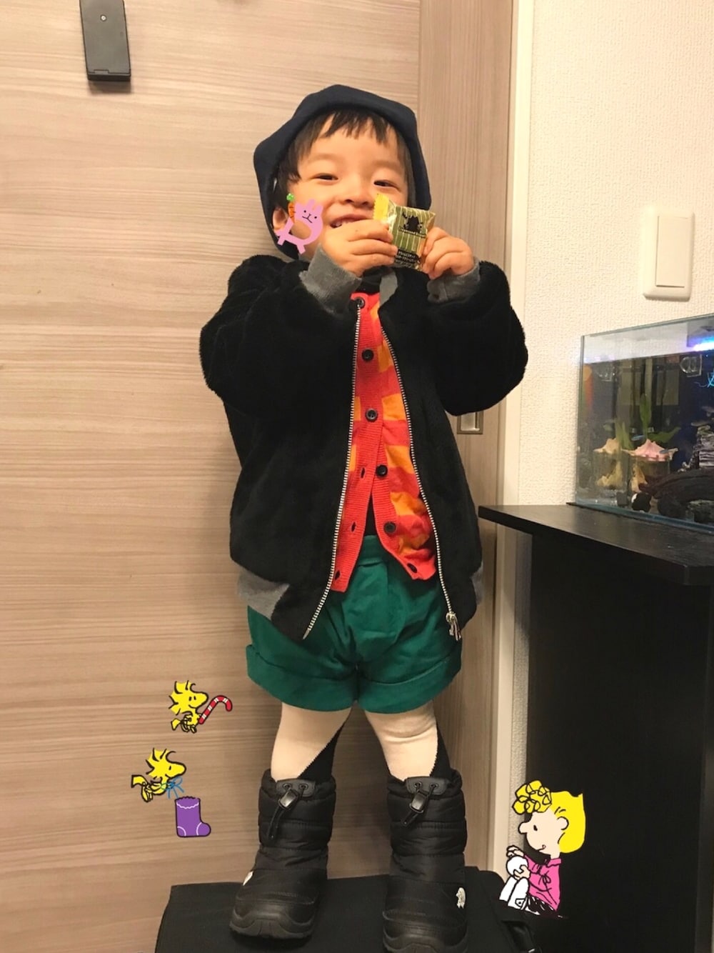 ピンク系のカーディガン/ボレロ、グリーン系のパンツ、ブラック系のブーツを着用したキッズの冬コーディネートの1枚目の写真