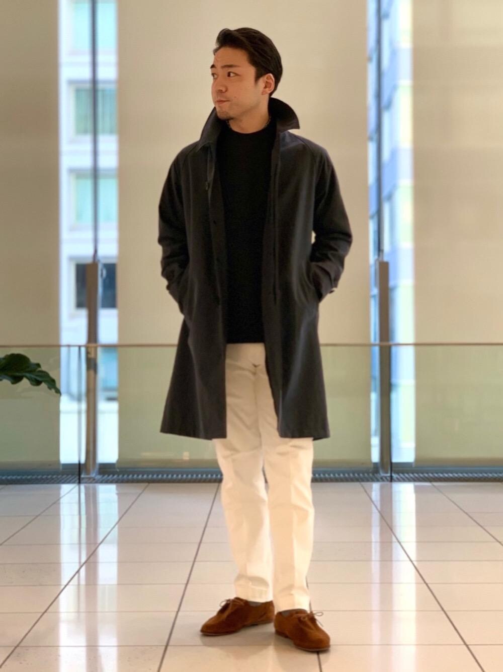 ブルー系のニット/セーター、ブルー系のステンカラーコート、ホワイト系のチノパンツを着用したメンズの冬コーディネートの1枚目の写真