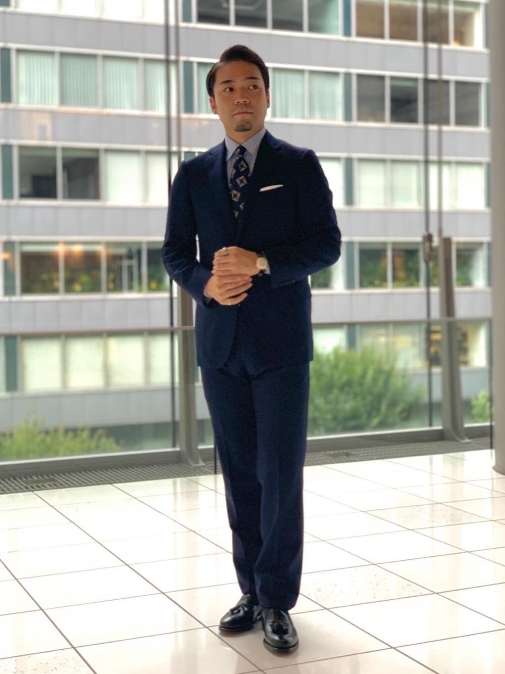 ブラック系のローファー、ブルー系のスーツジャケット、ブルー系のスーツパンツを着用したメンズの夏コーディネートの1枚目の写真