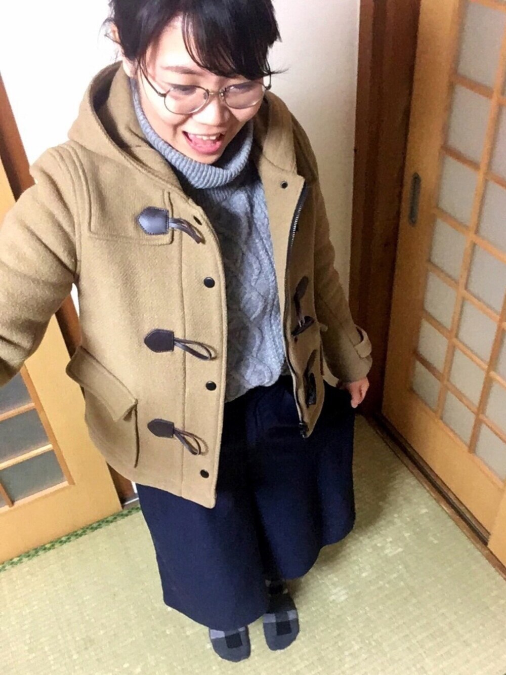 グレー系のニット/セーター、ブルー系のパンツ、イエロー系のダッフルコートを着用したレディースの冬コーディネートの1枚目の写真