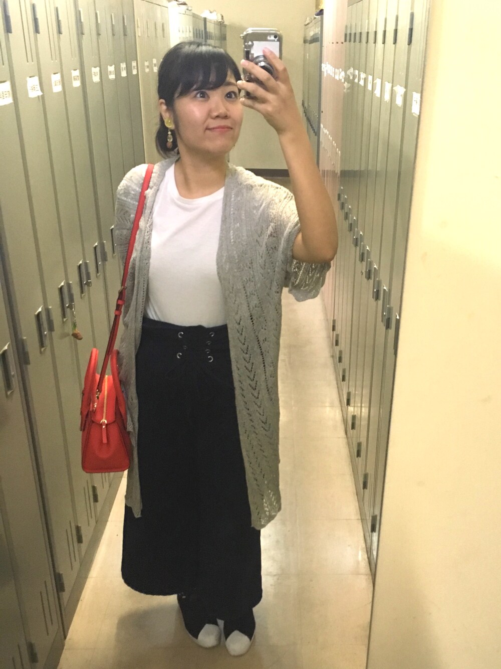 グレー系のカーディガン/ボレロ、イエロー系のキャミソール、ブルー系のデニムパンツを着用したレディースの秋コーディネートの1枚目の写真