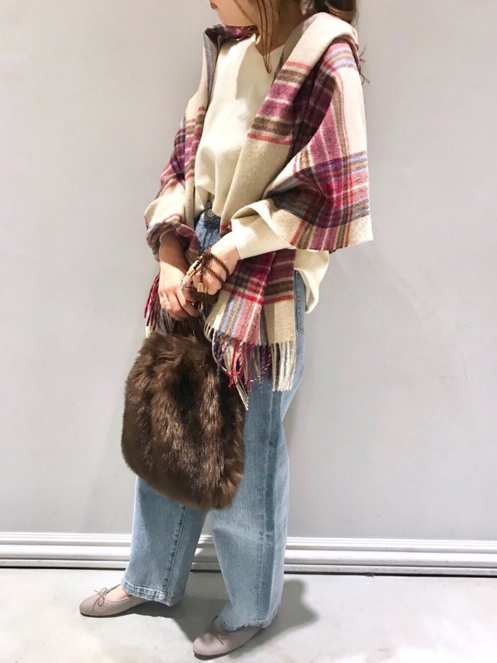 ベージュ系のニット/セーター、ブルー系のデニムパンツ、ブラウン系のトートバッグを着用したレディースの秋コーディネートの1枚目の写真