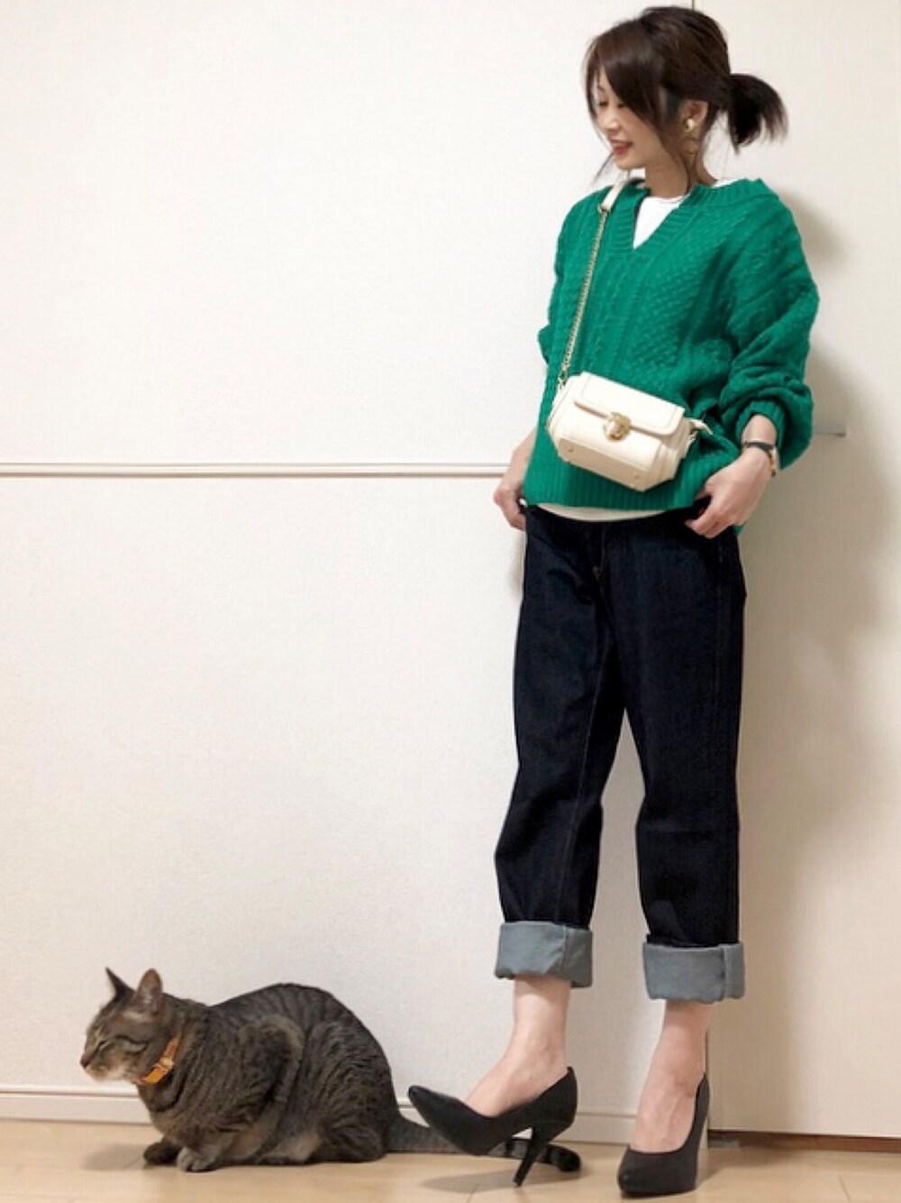 グリーン系のニット/セーター、ブルー系のデニムパンツ、ホワイト系のショルダーバッグを着用したレディースの秋コーディネートの1枚目の写真