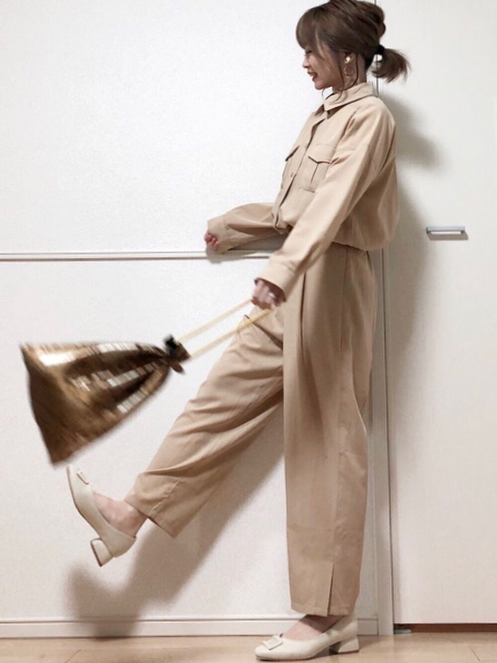 ベージュ系のワンピース、ブラウン系のハンドバッグ、ホワイト系のパンプスを着用したレディースの春コーディネートの1枚目の写真