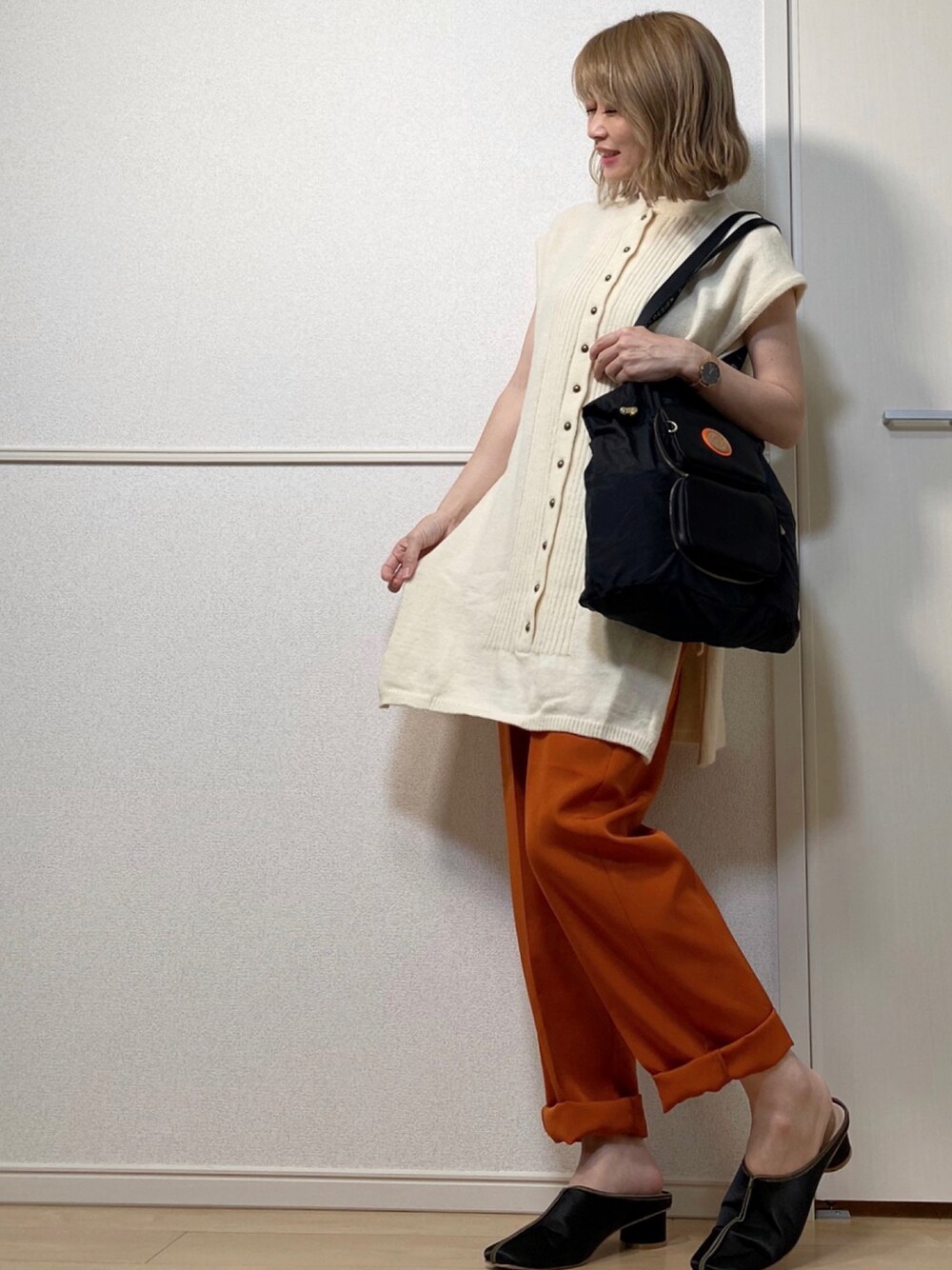 ホワイト系のベスト、ブラウン系のその他パンツ、ブラック系のトートバッグを着用したレディースの夏コーディネートの1枚目の写真