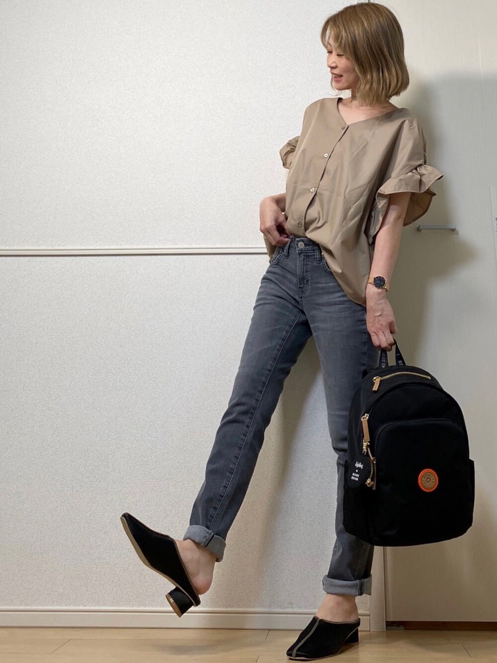 ブラウン系のシャツ/ブラウス、グレー系のデニムパンツ、ブラック系のバックパック/リュックを着用したレディースの秋コーディネートの1枚目の写真