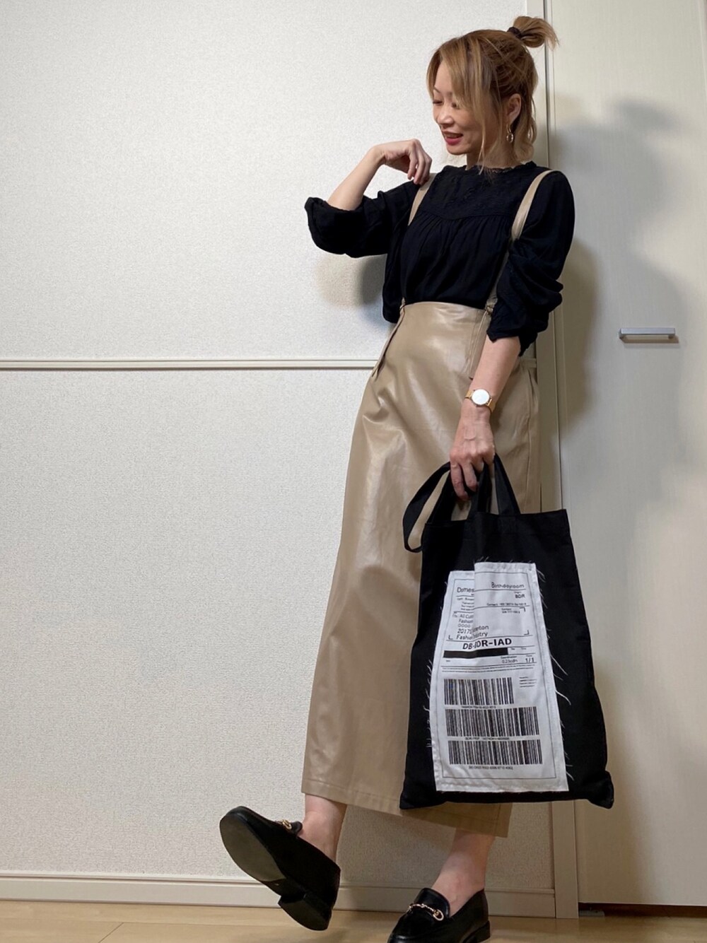 ベージュ系のスカート、ブラック系のエコバッグ/サブバッグ、ブラック系のシャツ/ブラウスを着用したレディースの秋コーディネートの1枚目の写真