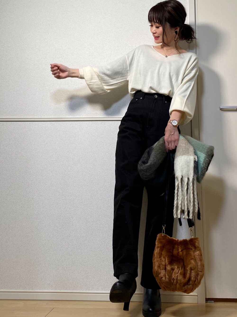 ホワイト系のニット/セーター、ブラック系のデニムパンツ、ブラウン系のショルダーバッグを着用したレディースの冬コーディネートの1枚目の写真