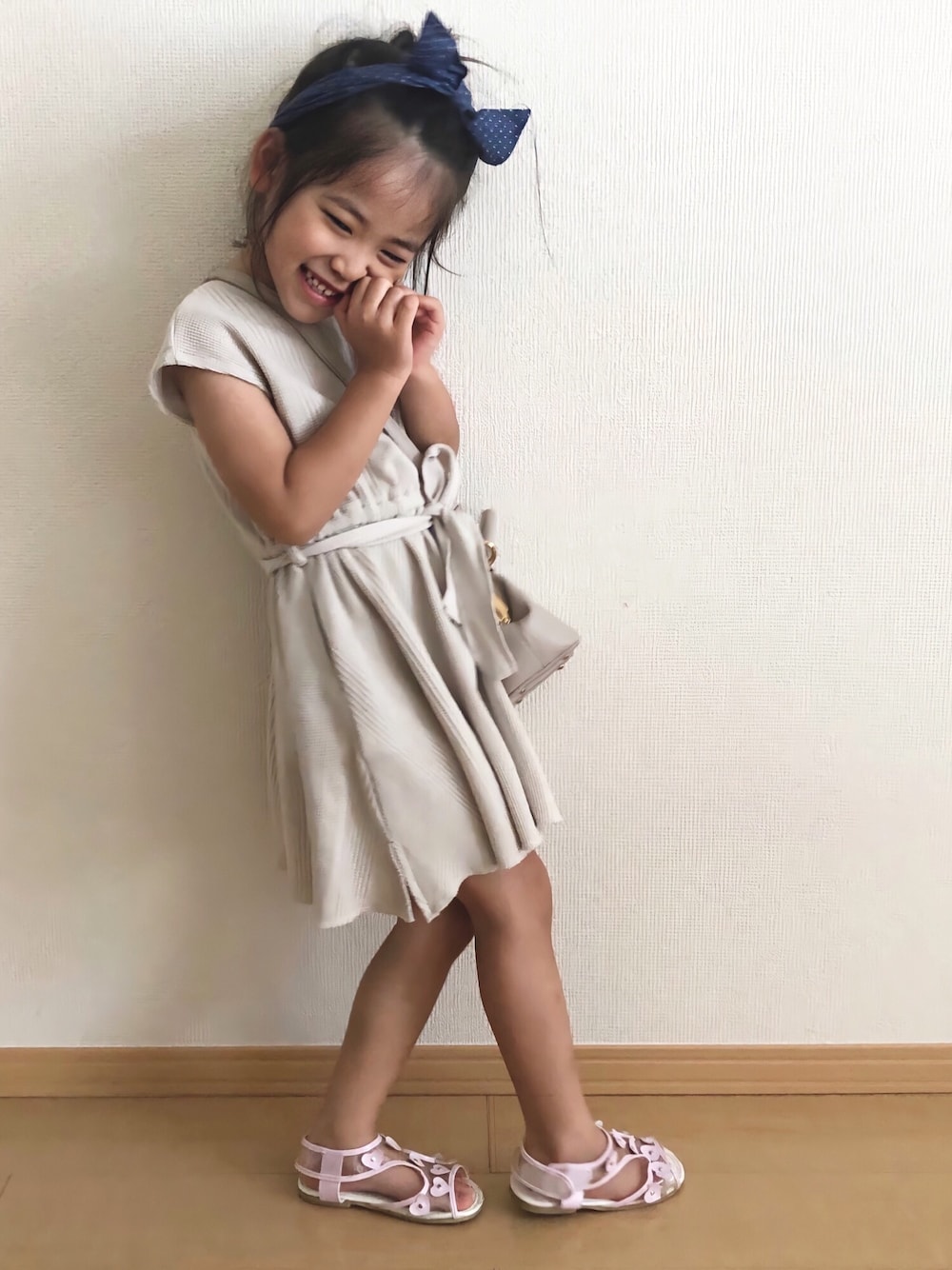 ピンク系のサンダル、ホワイト系のワンピース/ドレス、ピンク系のショルダーバッグを着用したキッズの夏コーディネートの1枚目の写真