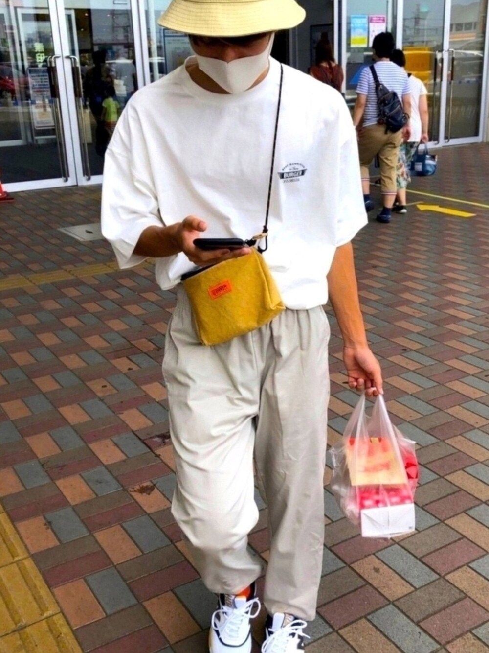 ホワイト系のパンツ、ホワイト系のTシャツ/カットソー、ベージュ系のバッグを着用したメンズの秋コーディネートの1枚目の写真