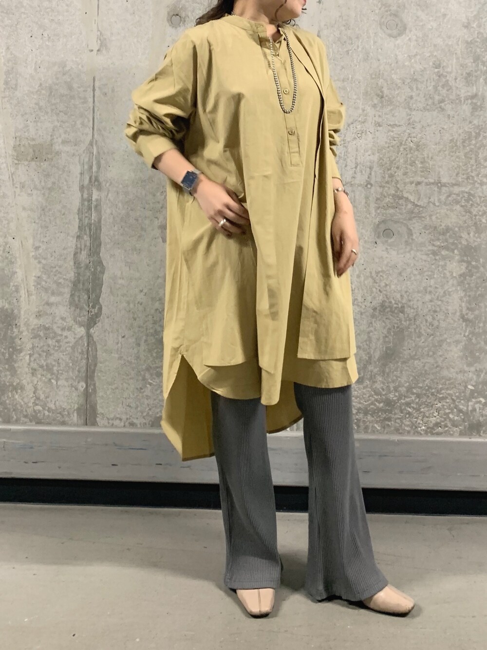 イエロー系のシャツ/ブラウス、グレー系のその他パンツ、ベージュ系のブーツを着用したレディースの秋コーディネートの1枚目の写真