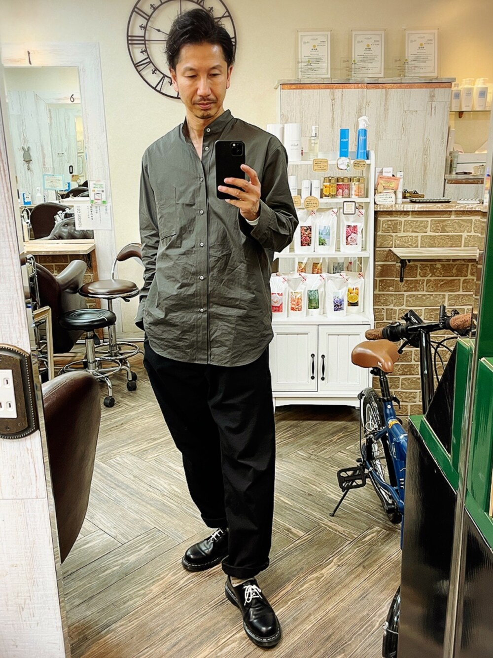 グレー系のシャツ/ブラウス、ブラック系のチノパンツ、ブラック系のブーツを着用したメンズの春コーディネートの1枚目の写真