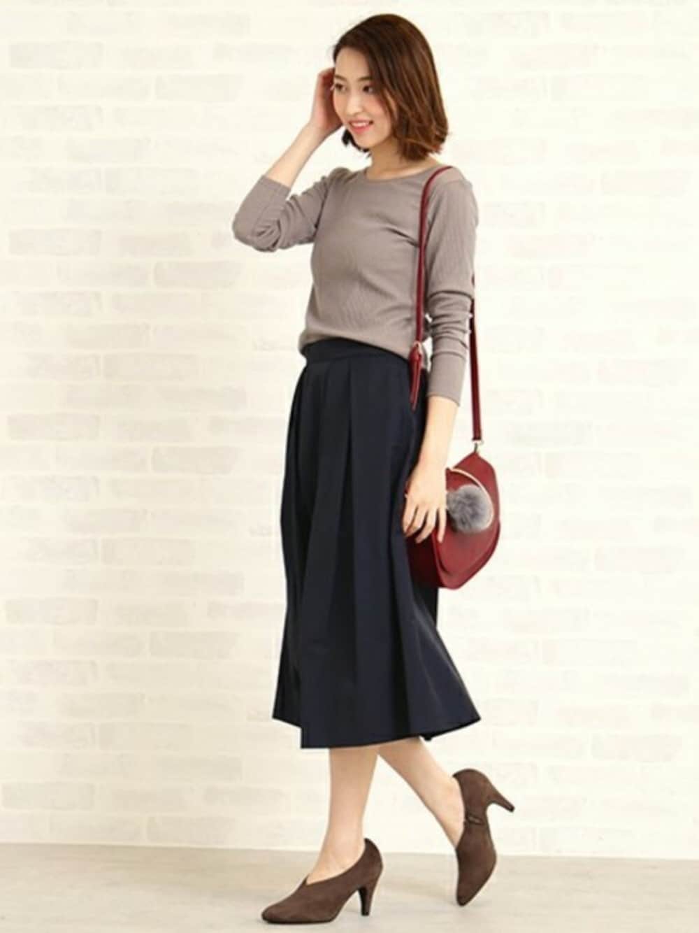 ベージュ系のTシャツ/カットソー、ブルー系のスカート、レッド系のショルダーバッグを着用したレディースの秋コーディネートの1枚目の写真