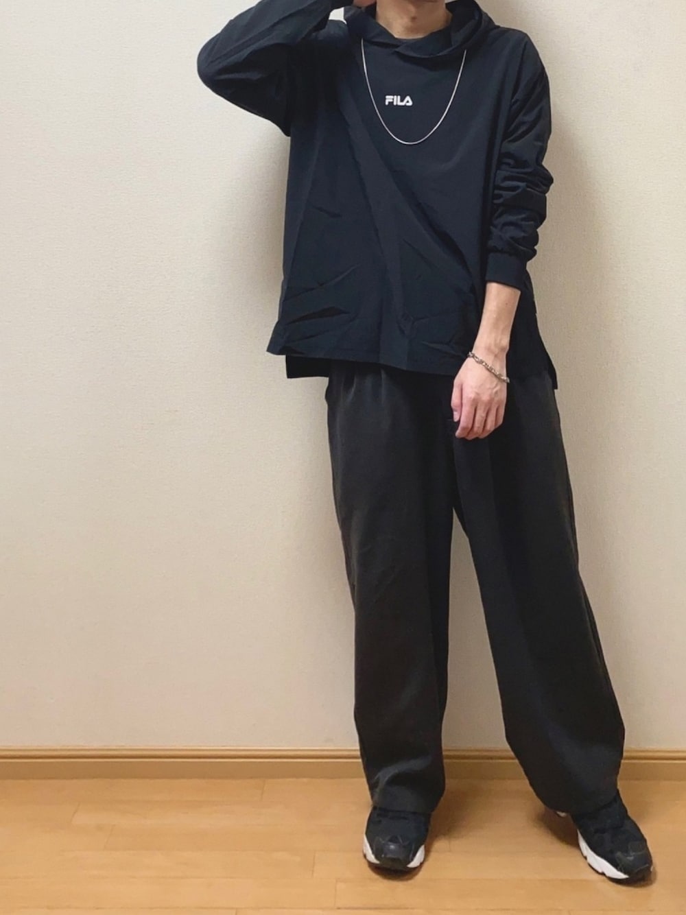 「春コーデ、オールブラック、黒、雨の日コーデ、ナイロンジャケット、パーカー、ワイドパンツ、シンプル、ネックレス、ブレスレット」｜「FILAの【FILA】ビッグシルエット針抜きパーカー  別注（パーカー、ブラック系）」を使った、Naoさん（メンズ・170cm）の春コーディネートの1枚目の写真