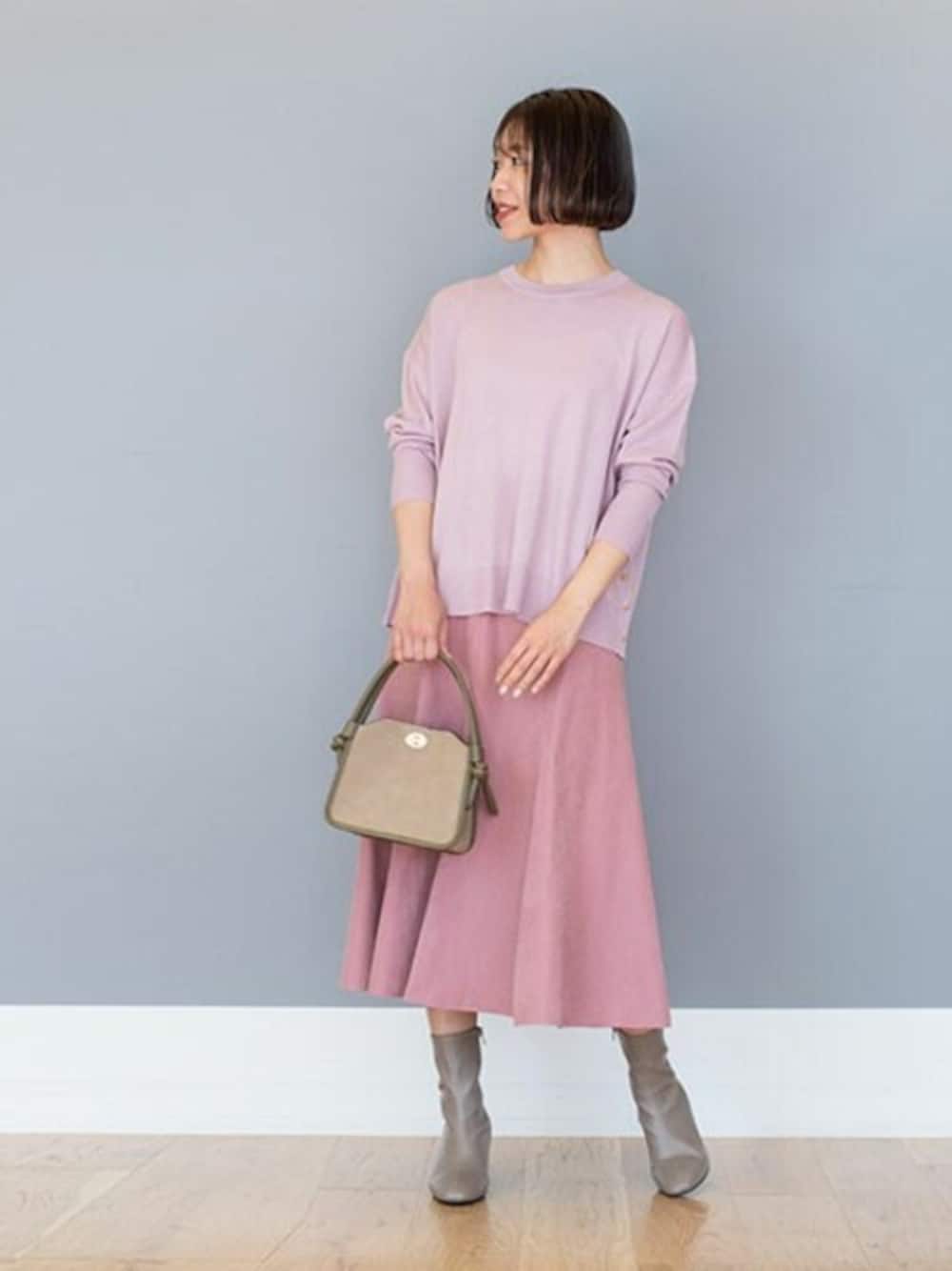 ピンク系のニット/セーター、ピンク系のスカート、グリーン系のトートバッグを着用したレディースの秋コーディネートの1枚目の写真