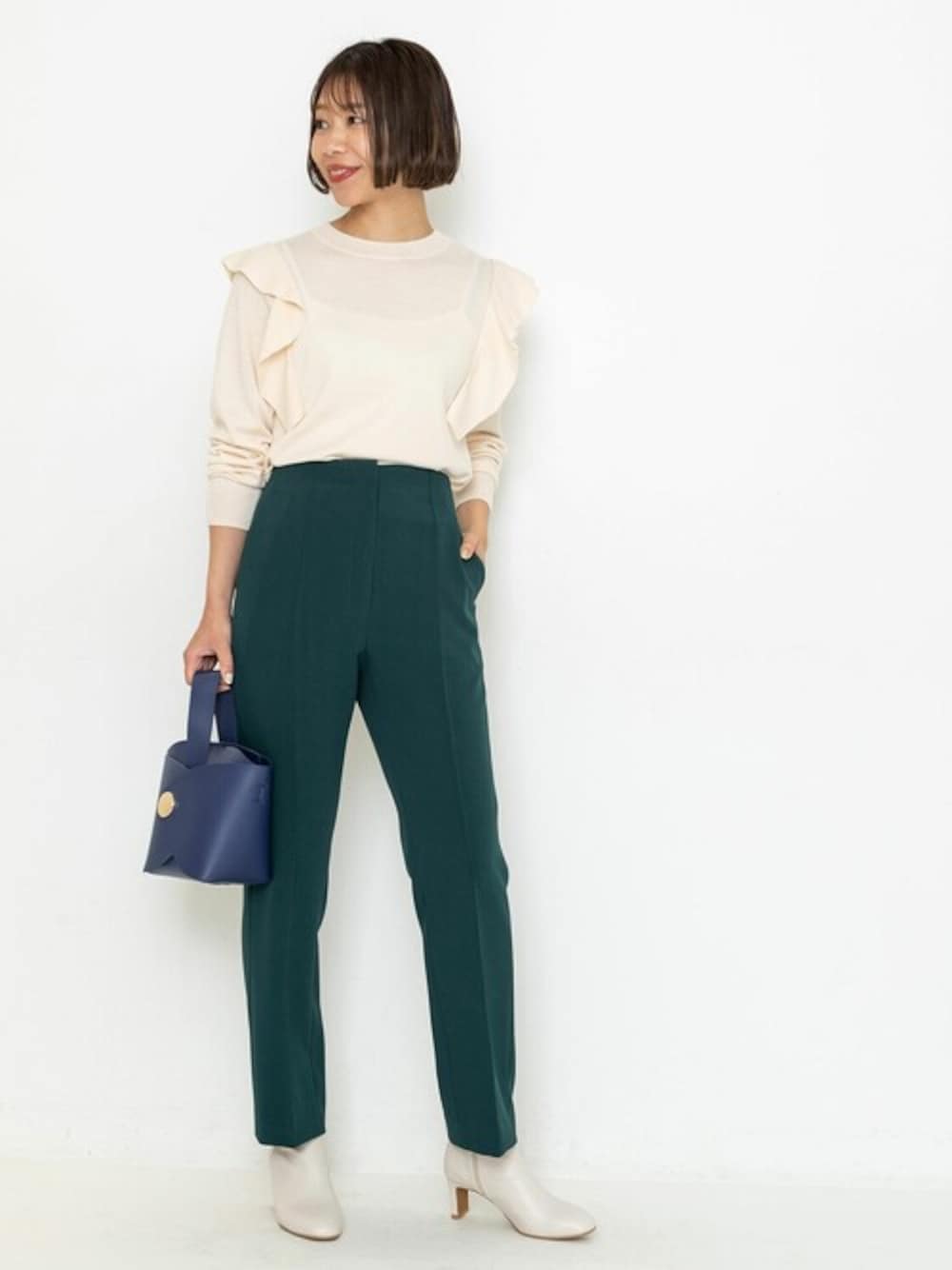 ホワイト系のニット/セーター、グリーン系のその他パンツ、ブルー系のハンドバッグを着用したレディースの秋コーディネートの1枚目の写真