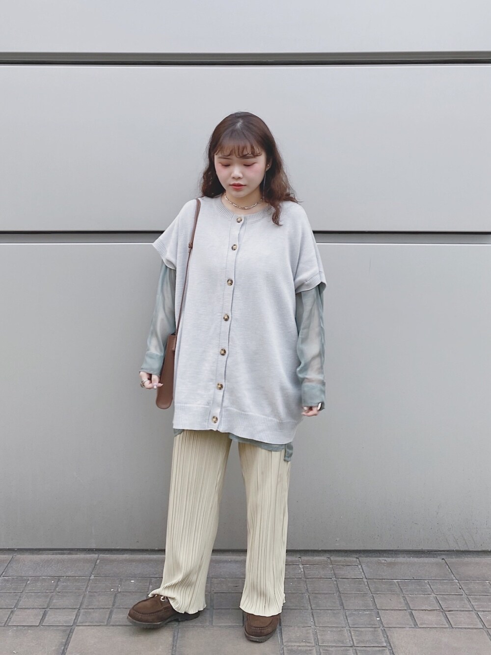 グレー系のトップス、グリーン系のシャツ/ブラウス、イエロー系のパンツを着用したレディースの春コーディネートの1枚目の写真