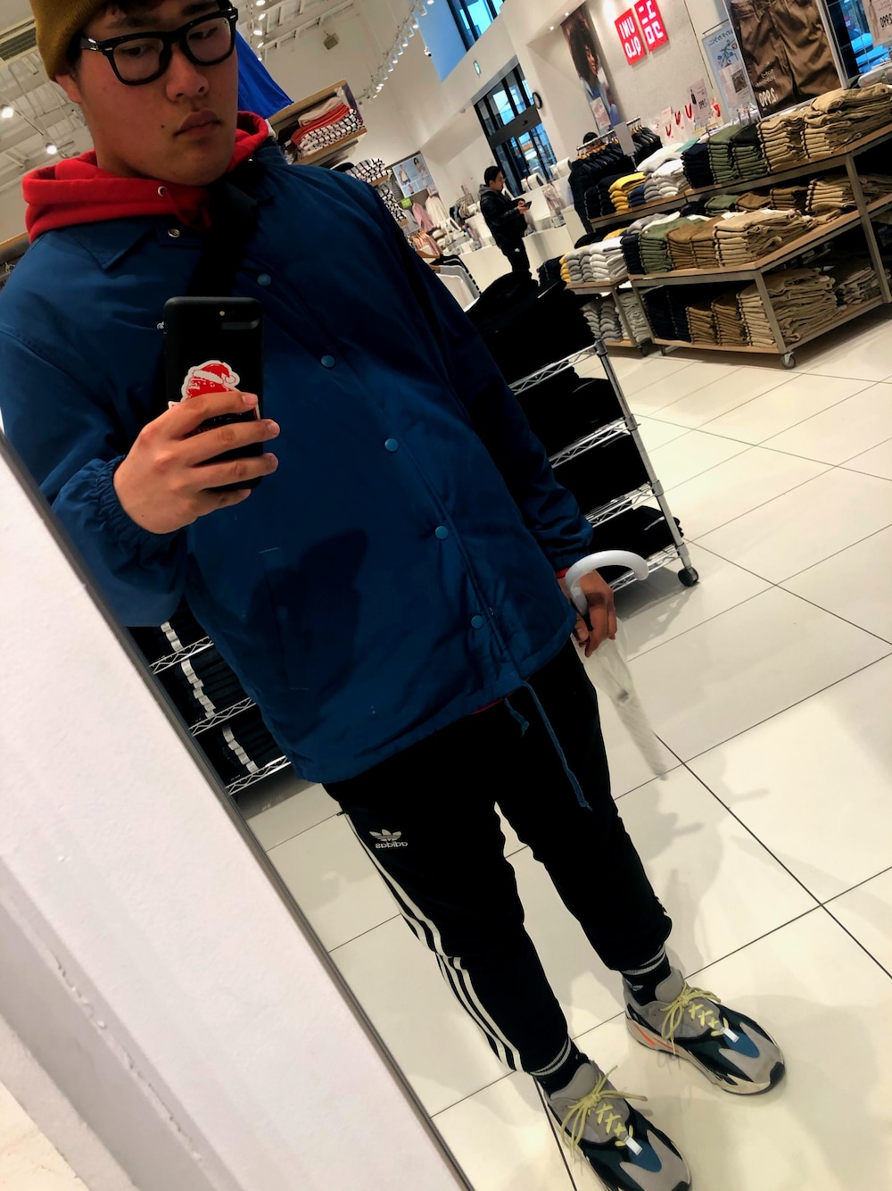 グリーン系のナイロンジャケット、ブラック系のその他パンツ、グレー系のスニーカーを着用したメンズの冬コーディネートの1枚目の写真