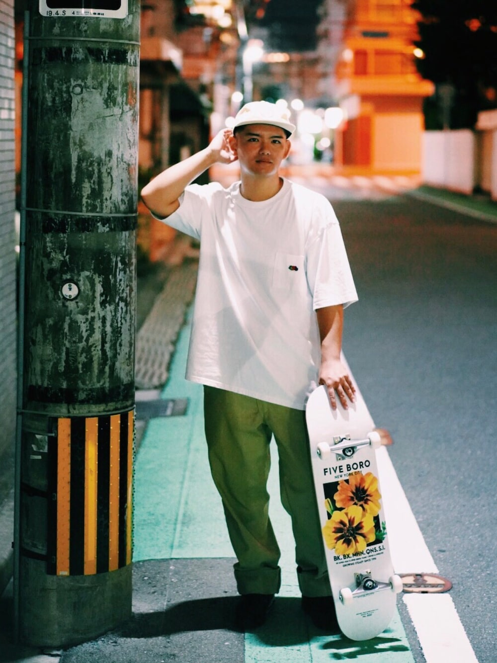 ホワイト系のTシャツ/カットソー、ベージュ系のチノパンツ、ブラック系のスニーカーを着用したメンズの冬コーディネートの1枚目の写真