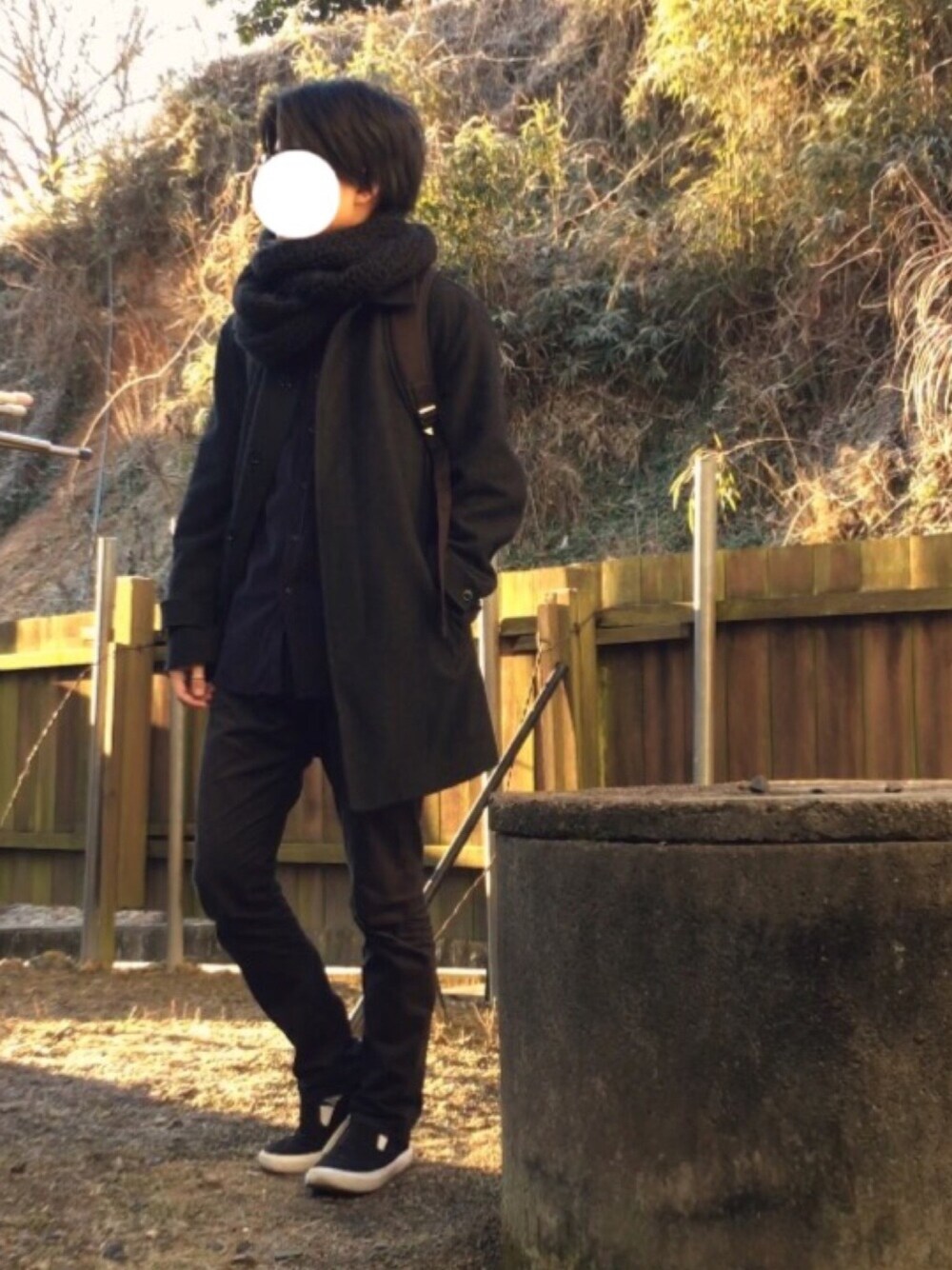 グレー系のステンカラーコート、ブラック系のバックパック/リュック、ブルー系のシャツ/ブラウスを着用したメンズの冬コーディネートの1枚目の写真