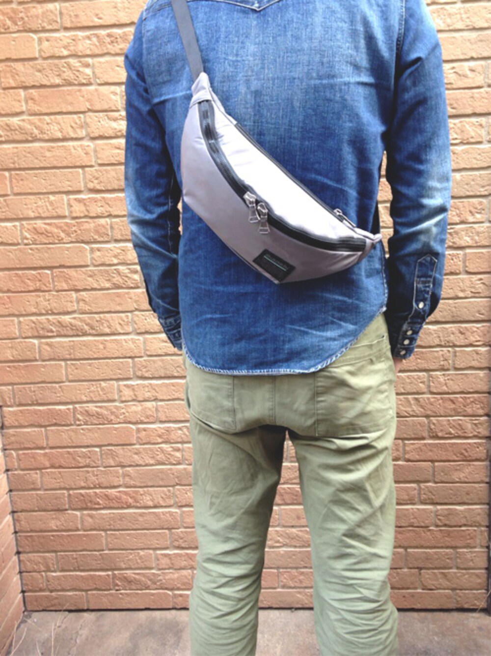 グレー系のボディバッグ/ウエストポーチを着用したメンズの冬コーディネートの1枚目の写真