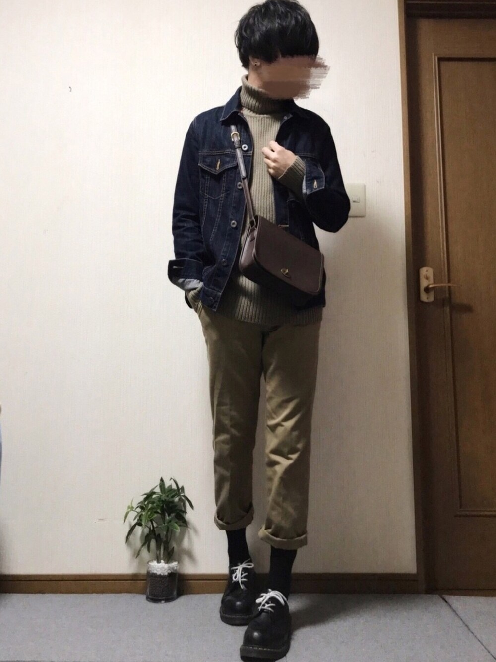 ブラウン系のニット/セーター、ブルー系のデニムジャケット、ブラウン系のショルダーバッグを着用したメンズの冬コーディネートの1枚目の写真