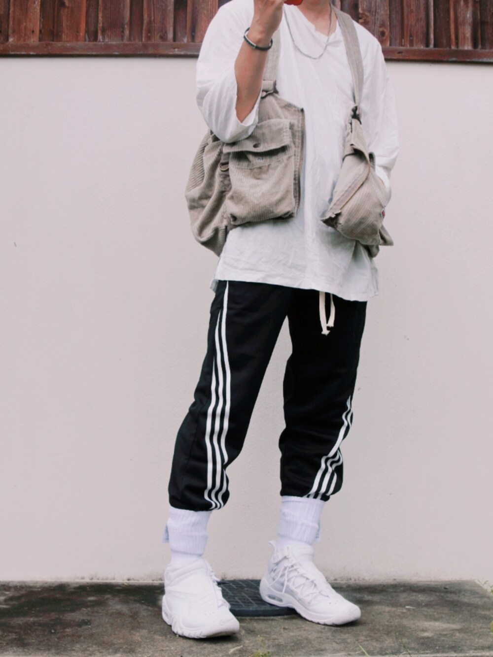 ベージュ系のベスト、ブラック系のその他パンツ、ホワイト系のスニーカーを着用したメンズの秋コーディネートの1枚目の写真