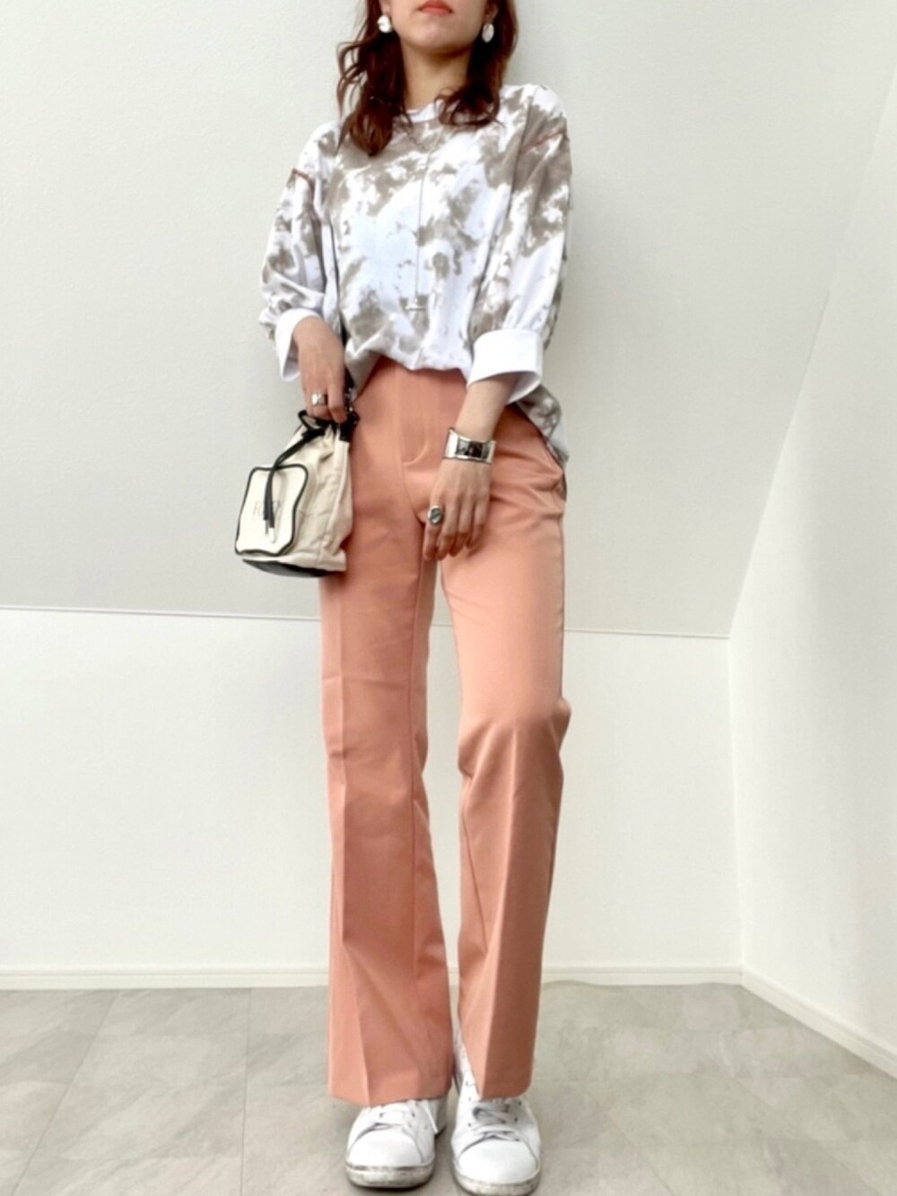 ブラウン系のTシャツ/カットソー、オレンジ系のパンツ、ホワイト系のショルダーバッグを着用したレディースの春コーディネートの1枚目の写真