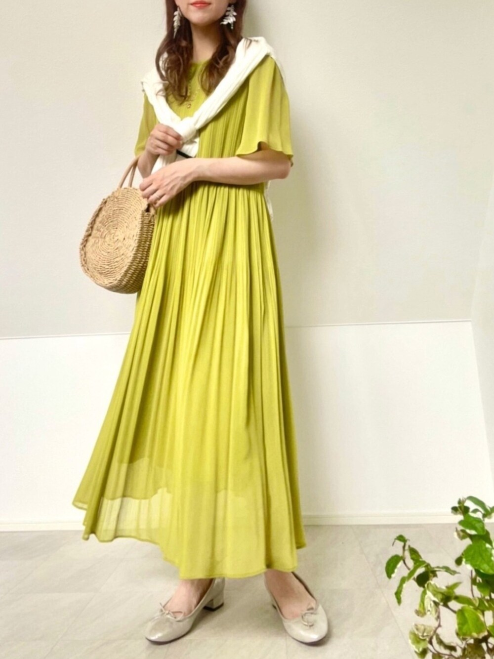 グリーン系のワンピース、ホワイト系のカーディガン/ボレロ、ベージュ系のかごバッグを着用したレディースの夏コーディネートの1枚目の写真