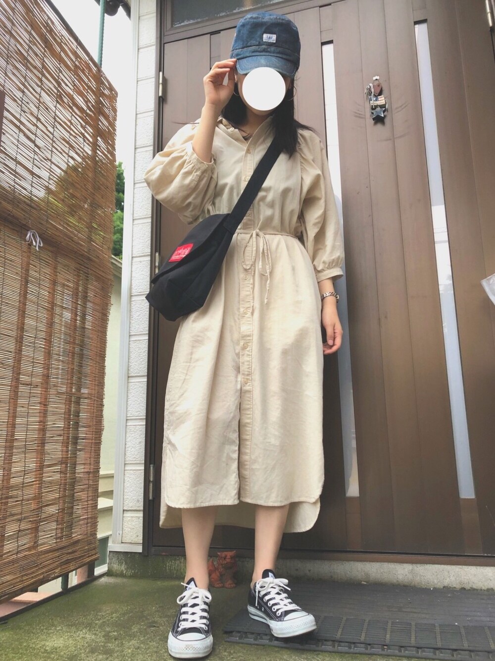 ブラック系のスニーカー、ブラック系のショルダーバッグ、ベージュ系のシャツワンピースを着用したレディースの夏コーディネートの1枚目の写真
