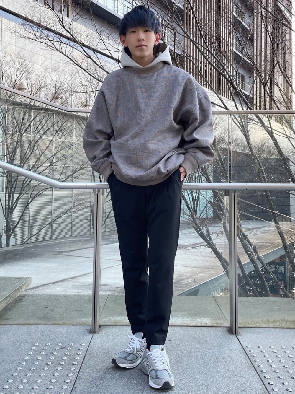 グレー系のスウェット、ベージュ系のパーカー、ブラック系のスラックスを着用したメンズの冬コーディネートの1枚目の写真