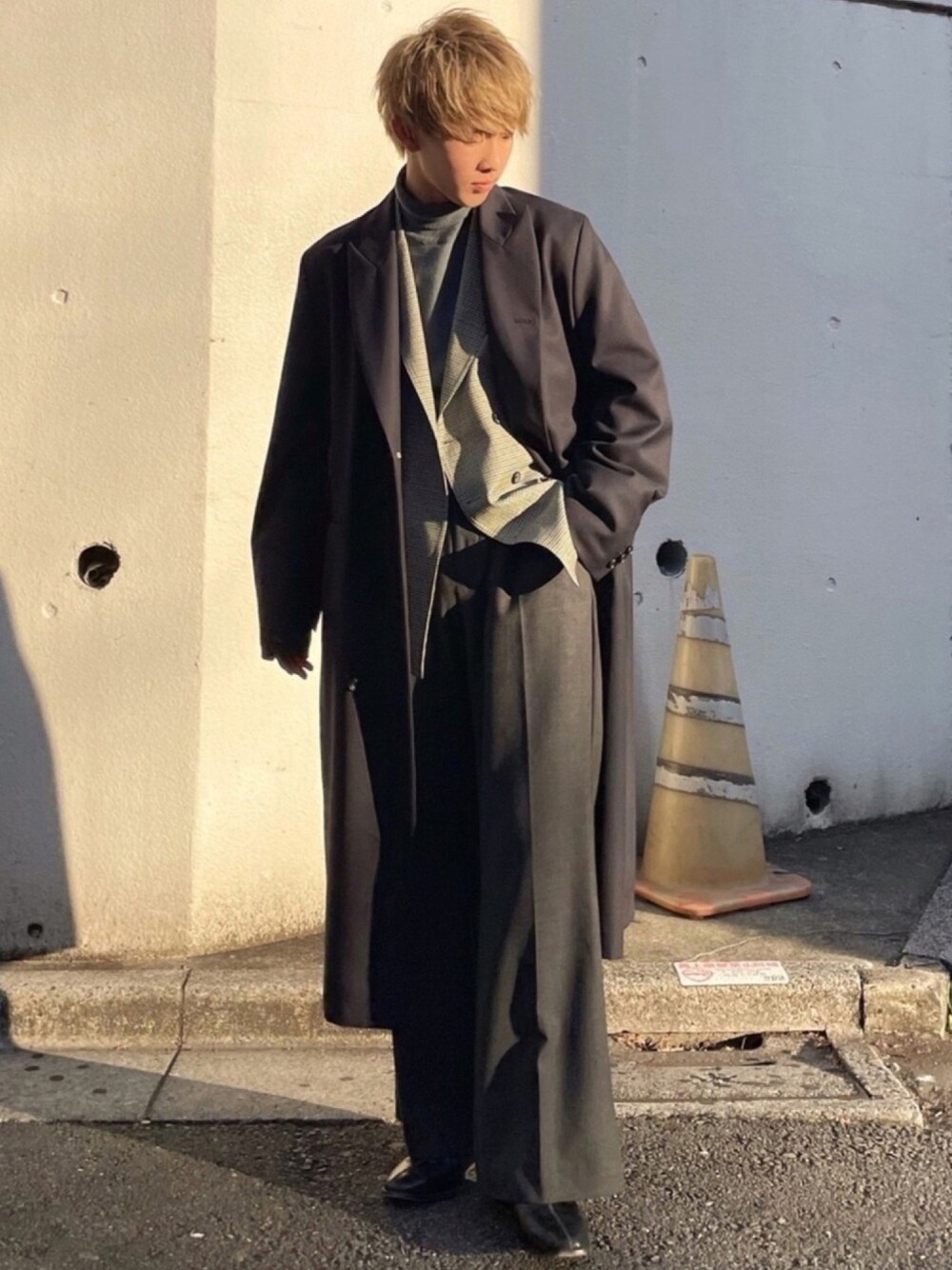 ブルー系のチェスターコート、グリーン系のテーラードジャケット、ブルー系のニット/セーターを着用したメンズの春コーディネートの1枚目の写真