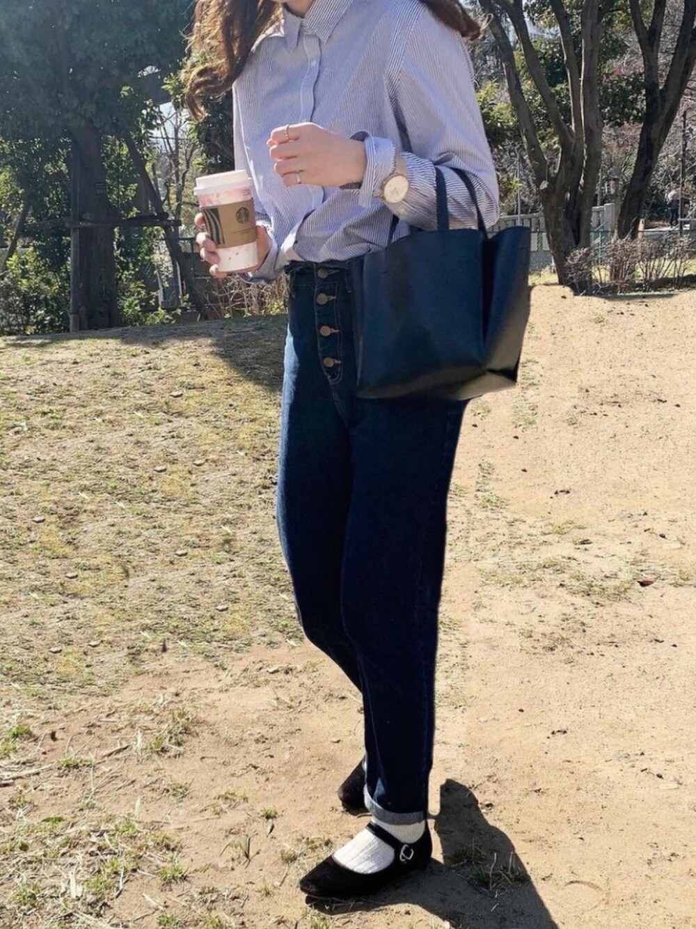 ブルー系のデニムパンツ、ブルー系のシャツ/ブラウス、ブラック系のトートバッグを着用したレディースの冬コーディネートの1枚目の写真