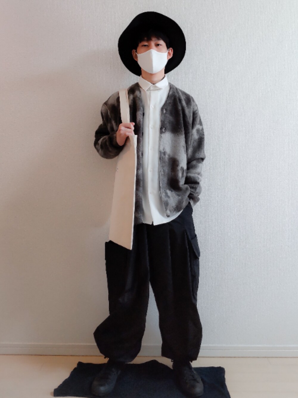 ホワイト系のシャツ/ブラウス、ブラック系のカーディガン/ボレロ、ベージュ系のトートバッグを着用したメンズの春コーディネートの1枚目の写真