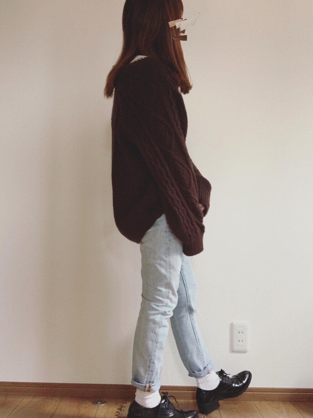 ブラウン系のカーディガン/ボレロ、ブルー系のデニムパンツ、ブラック系のドレスシューズを着用したレディースの冬コーディネートの1枚目の写真