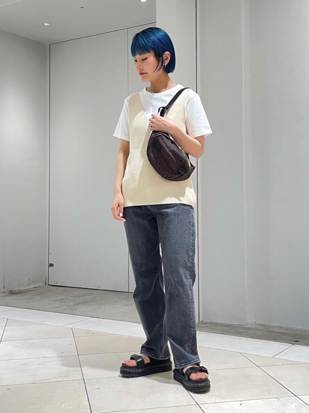 ブラウン系のボディバッグ/ウエストポーチ、ブラック系のデニムパンツ、ブラック系のサンダルを着用したレディースの春コーディネートの1枚目の写真