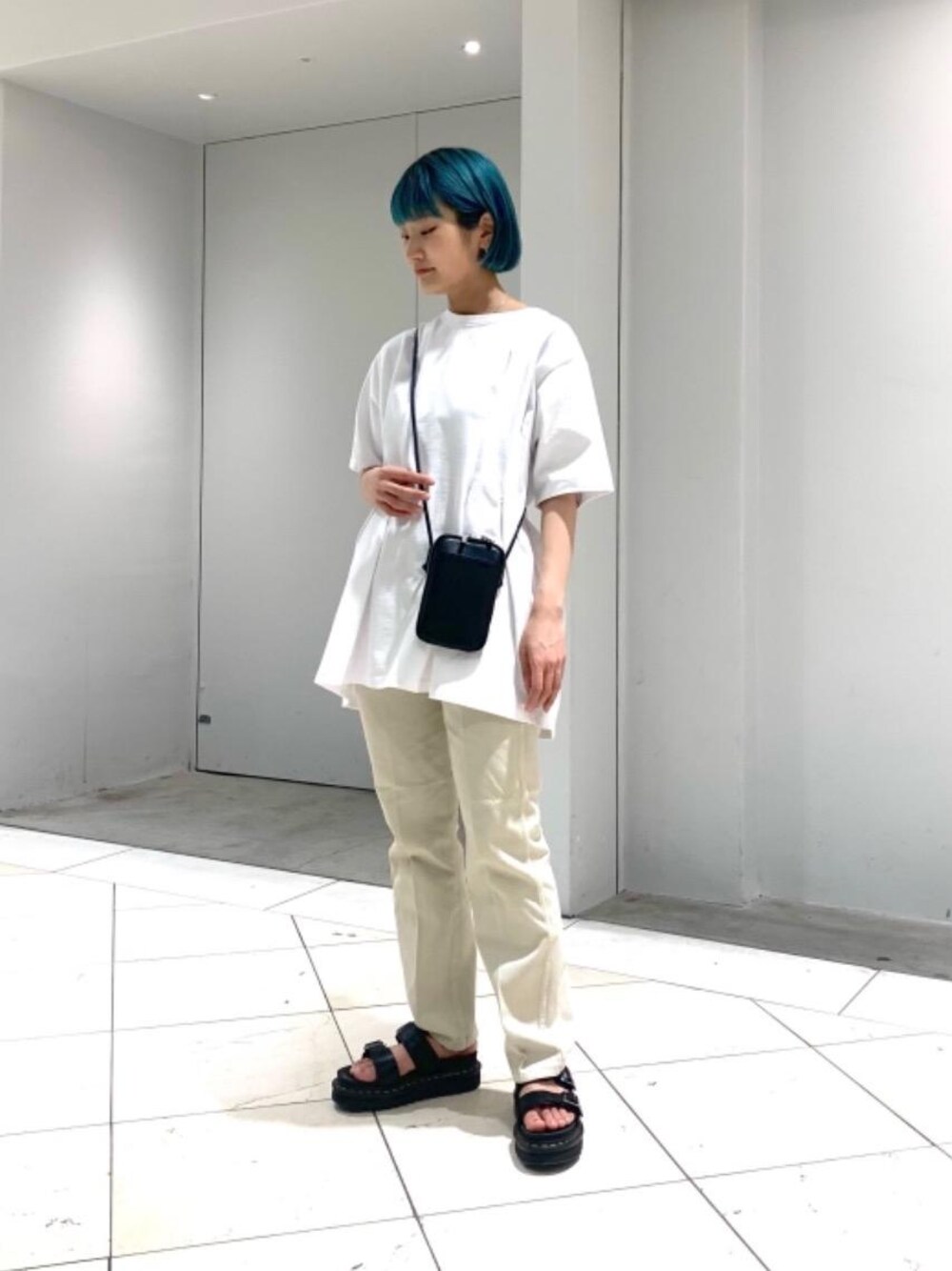 ベージュ系のデニムパンツ、ホワイト系のTシャツ/カットソー、ブラック系のサンダルを着用したレディースの春コーディネートの1枚目の写真